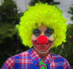Portrait of boy in clown costume and face paint