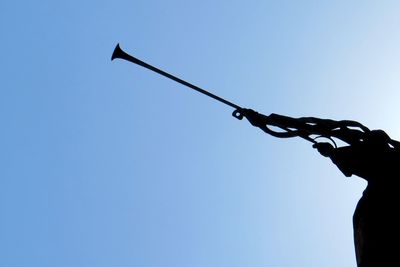 Low angle view of silhouette person against clear blue sky