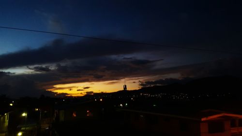 Silhouette city against sky at dusk