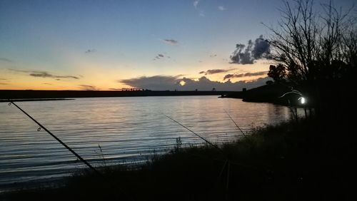 Scenic view of lake against sky at sunset