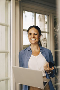 Portrait of smiling young woman using smart phone