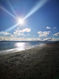 Scenic view of sea against bright sun