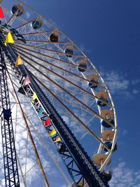 Low angle view of ferris wheel against blue sky