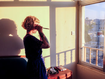Woman standing by window