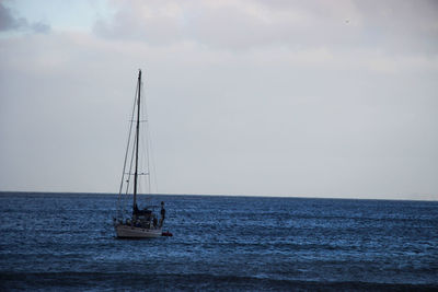 Sailboat sailing on sea against sky