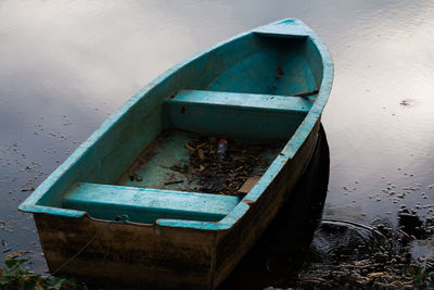 High angle view of abandoned rowboat moored at lakeshore