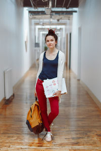 Portrait of smiling woman standing on hardwood floor