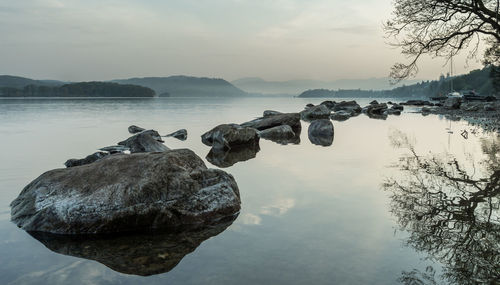 Rocks in lake against sky