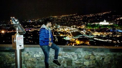 High angle view of man holding illuminated cityscape at night