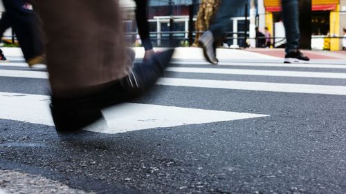 Low section of people walking on road