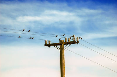 Low angle view of electricity pylon against sky