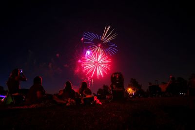 People watching firework display at night