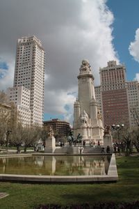 Cervantes monument and buildings at plaza de espana against cloudy sky