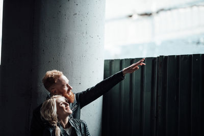 Portrait of woman standing against wall