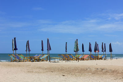 Closed canopies on beach against the sky