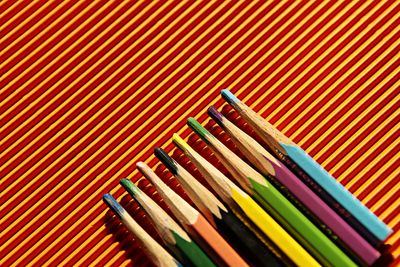 High angle view of multi colored pencils over abstract background