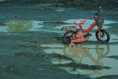 Bicycle toy on shore at lake