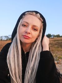 Portrait of smiling woman against clear sky