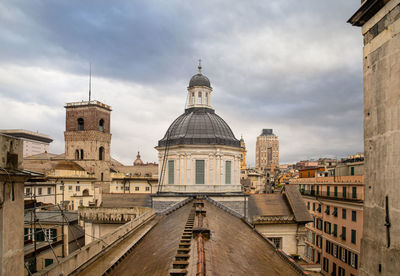 View of buildings in city against cloudy sky