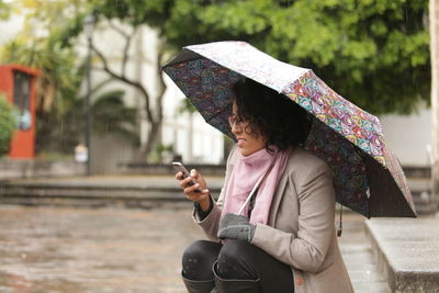 Midsection of woman using mobile phone outdoors