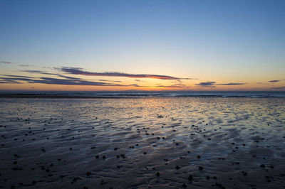 Scenic view of beach against sky during sunset