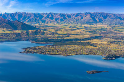 Aerial view of lake by mountain against sky