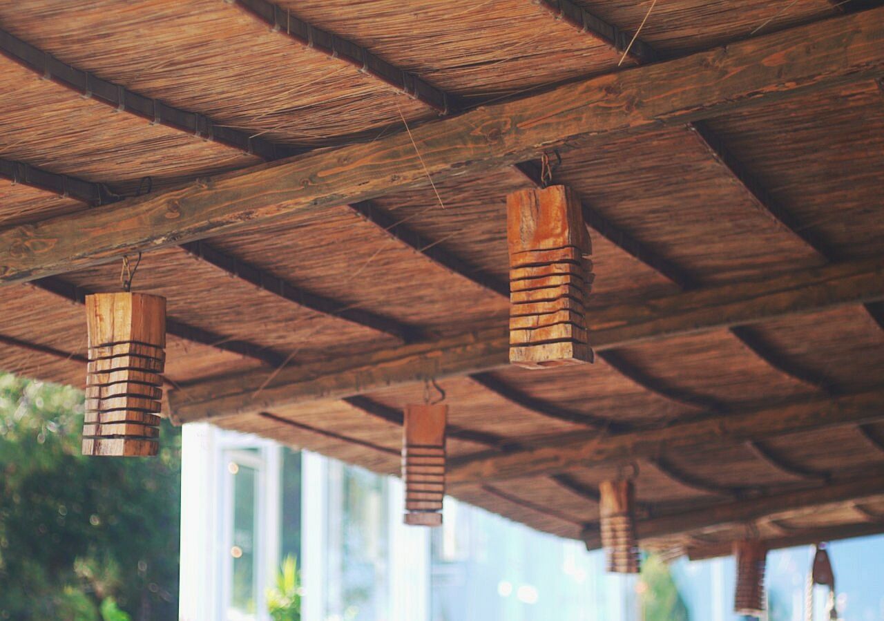 built structure, wood - material, architecture, no people, low angle view, day, ceiling, indoors, roof, architectural column, focus on foreground, pattern, building, sunlight, nature, roof beam, in a row, selective focus, construction industry