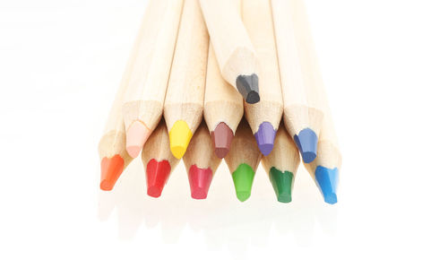 High angle view of multi colored pencils on white background