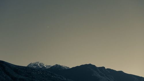 Scenic view of snowcapped mountains against clear sky