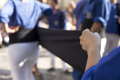 Close-up of hands helping man in wearing uniform