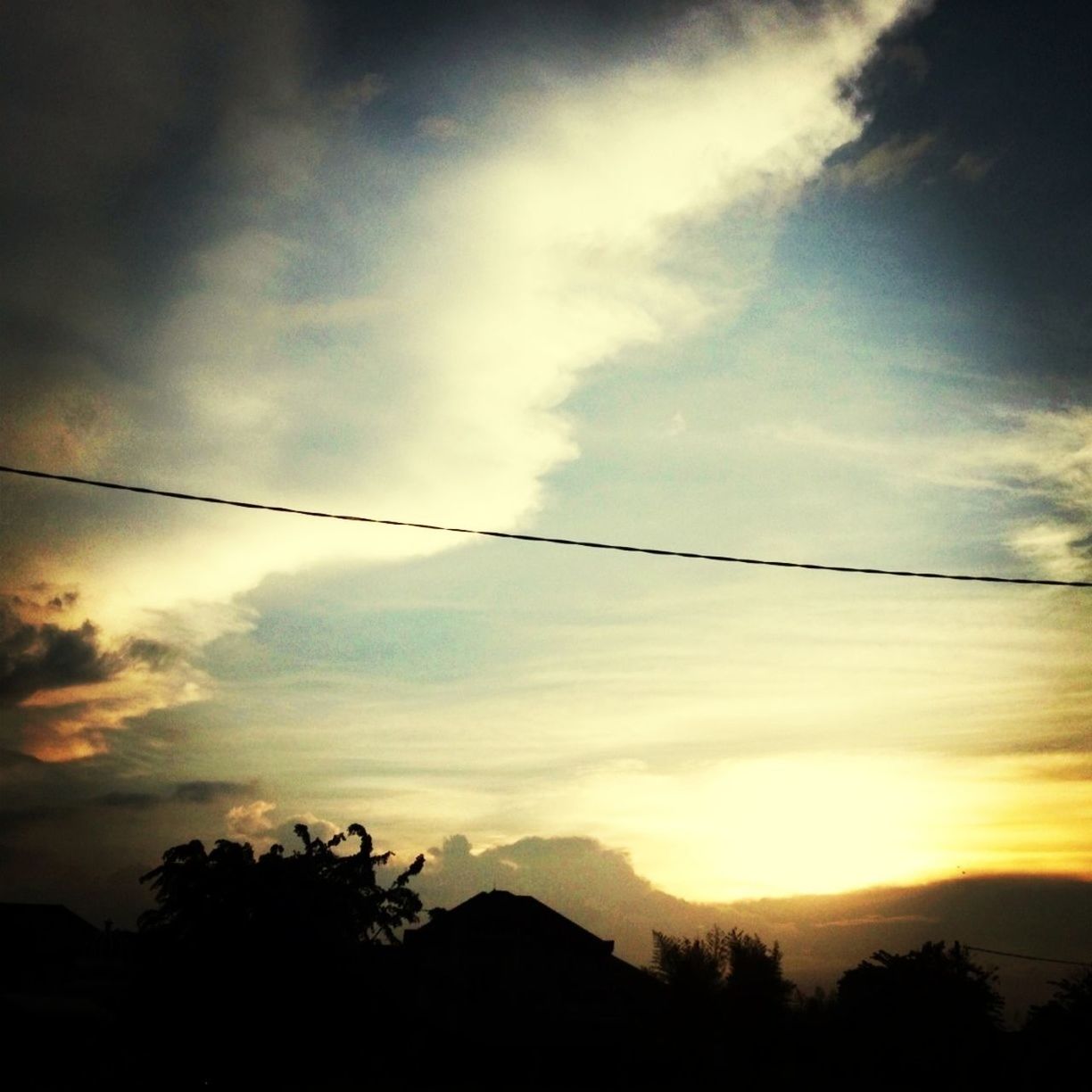 silhouette, sky, sunset, tranquility, scenics, cloud - sky, tranquil scene, beauty in nature, tree, low angle view, cloud, nature, cloudy, mountain, power line, idyllic, dusk, outdoors, no people, landscape