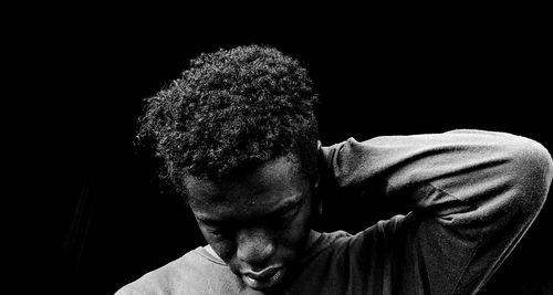Close-up portrait of a boy against black background