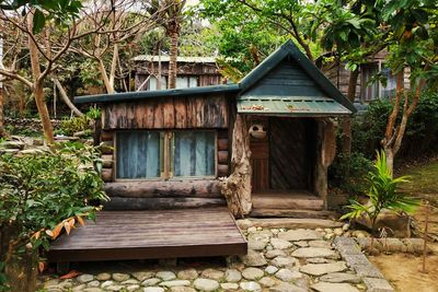 Wooden house by trees in forest