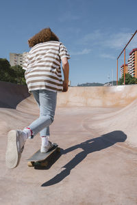 Young man skateboarding at sports ramp on sunny day