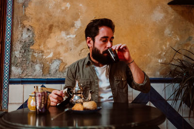 Young man sitting on table in restaurant