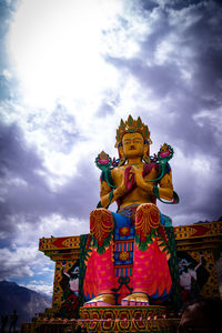 Low angle view of statue against temple building against sky