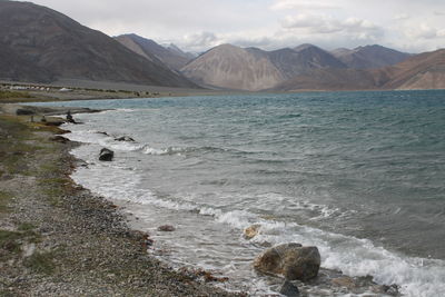 Scenic view of sea and mountains against sky