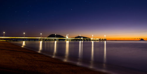 View of illuminated pier at night