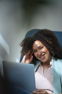 Happy businesswoman with laptop in office