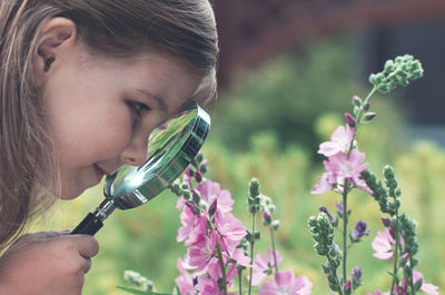 Close-up portrait of girl holding flowering plant