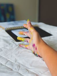 Cropped image of messy hand on bed