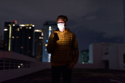 Full length of young man standing in city at night