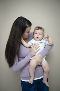 Side view of mother and daughter at home