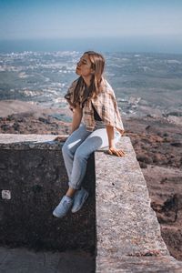 Young woman sitting on rock