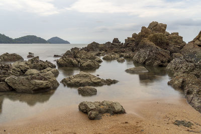 Rocks on sea shore against sky