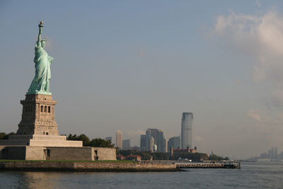 Statue of liberty with city skyline in background