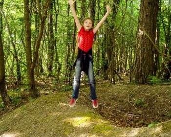 Full length portrait of smiling boy in forest