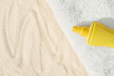 High angle view of yellow and hat on sand