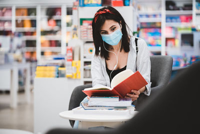 Young woman reading book in library