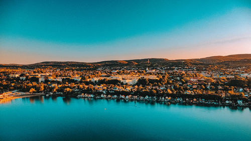 Aerial view of townscape against blue sky